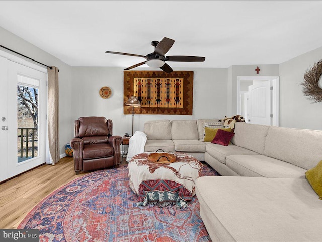 living area featuring ceiling fan, wood finished floors, and french doors