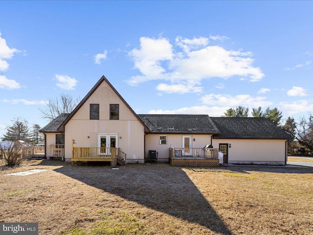 rear view of house with a deck, central AC, french doors, and a shingled roof