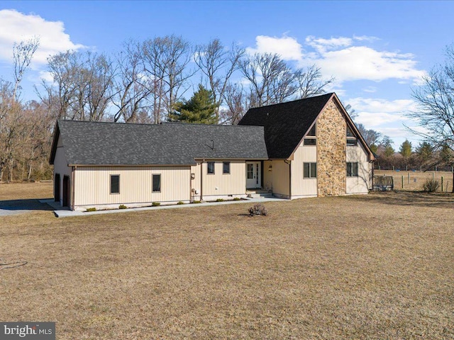 modern farmhouse featuring a shingled roof and a front yard