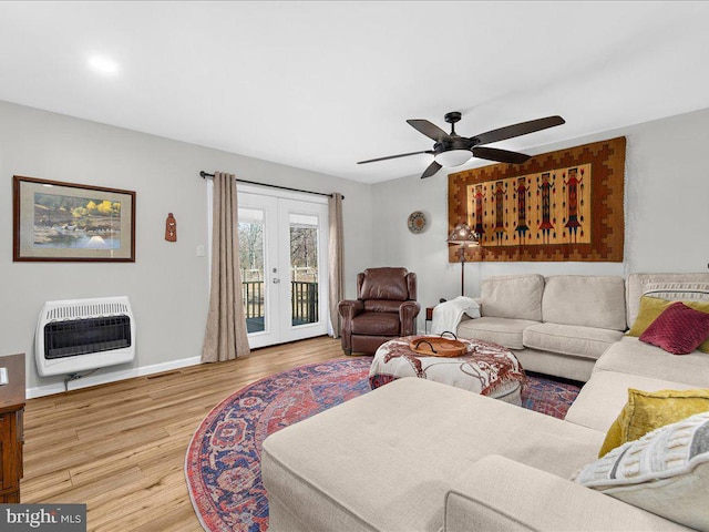 living room with baseboards, a ceiling fan, wood finished floors, heating unit, and french doors