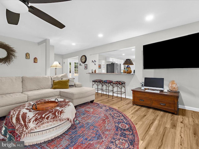 living area featuring recessed lighting, ceiling fan, light wood-style flooring, and baseboards