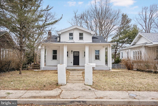 bungalow with a porch, a front yard, roof with shingles, and fence