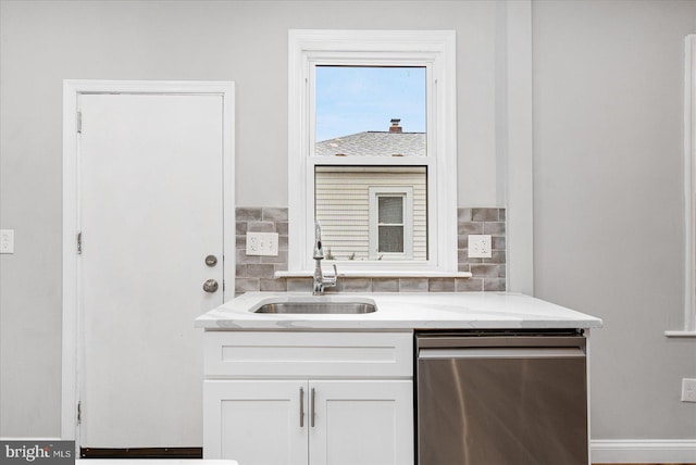 kitchen featuring a sink, white cabinets, light stone countertops, dishwasher, and tasteful backsplash