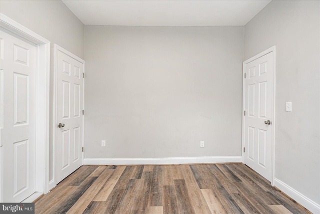 unfurnished room featuring wood finished floors and baseboards