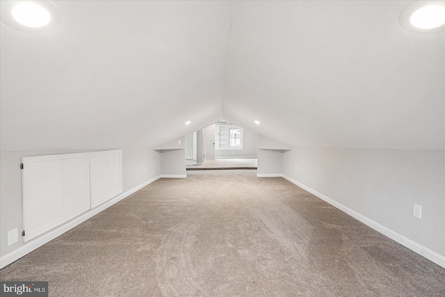 additional living space with carpet floors, lofted ceiling, and baseboards