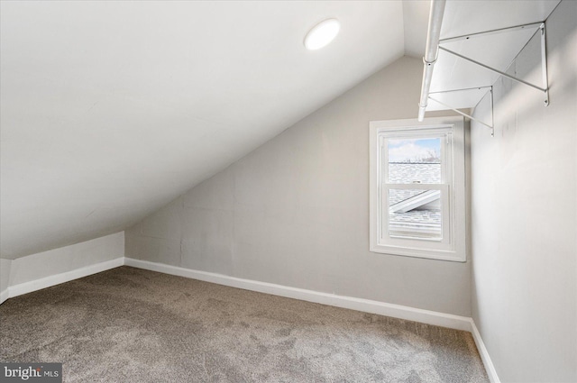 additional living space featuring carpet floors, baseboards, and lofted ceiling