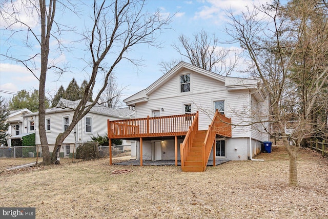 rear view of property featuring fence, stairway, and a deck