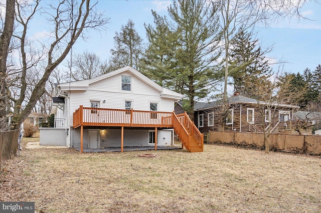 rear view of house with a yard, fence, stairway, and a wooden deck