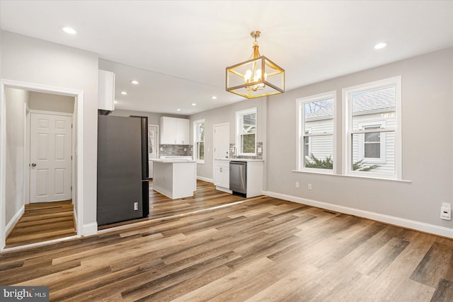 kitchen featuring stainless steel appliances, tasteful backsplash, white cabinetry, and a healthy amount of sunlight