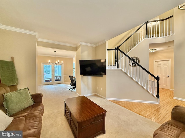 living room with carpet, stairway, an inviting chandelier, wood finished floors, and baseboards