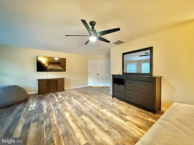 living area featuring visible vents, ceiling fan, baseboards, and wood finished floors