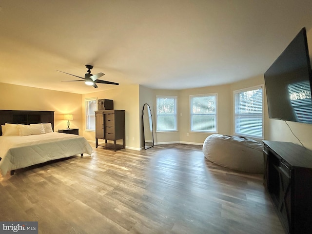 bedroom featuring ceiling fan, baseboards, and wood finished floors