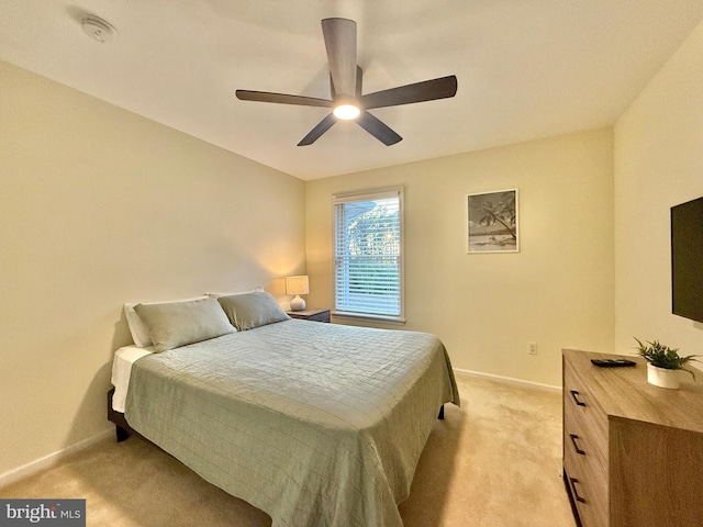 bedroom with baseboards, a ceiling fan, and light colored carpet