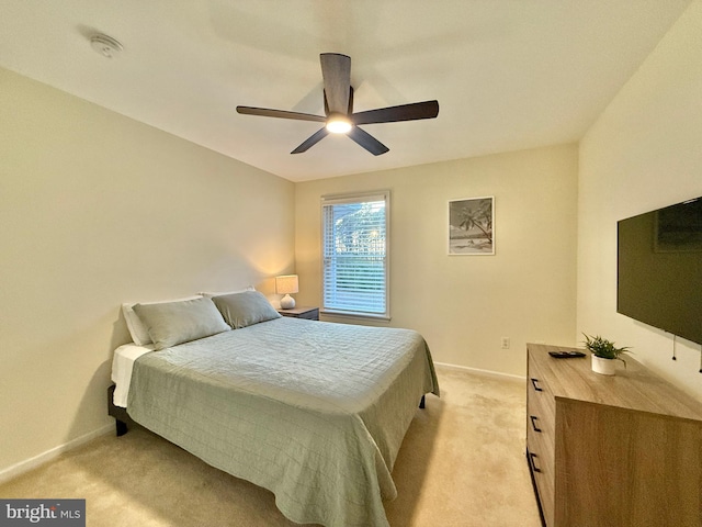 bedroom with light carpet, ceiling fan, and baseboards