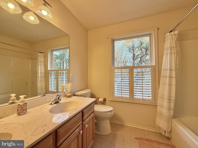 bathroom featuring double vanity, baseboards, toilet, tile patterned floors, and a sink