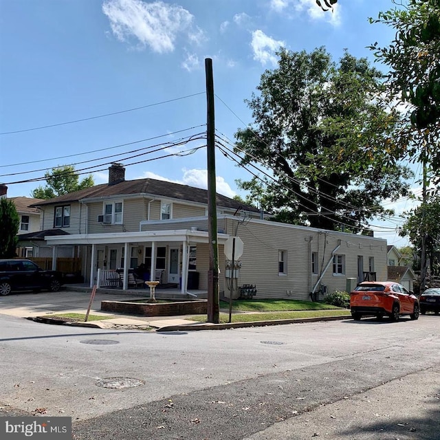 townhome / multi-family property with a porch and a chimney