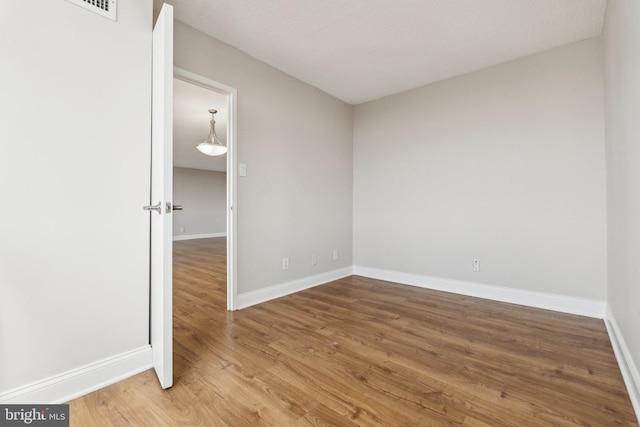 unfurnished room with baseboards and wood finished floors