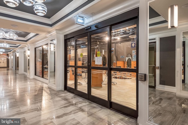 wine cellar featuring a notable chandelier, french doors, a raised ceiling, and crown molding