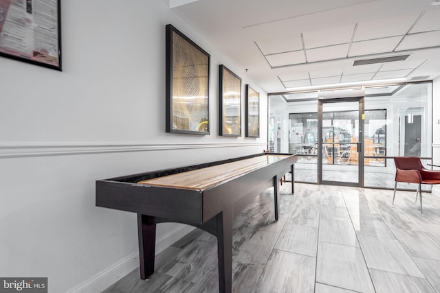 rec room featuring a wall of windows, french doors, baseboards, and visible vents