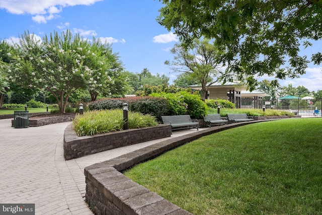 view of community with a yard and fence