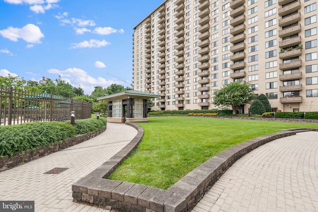 view of community featuring a yard and fence