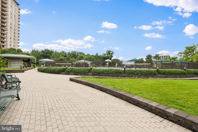 view of property's community with a yard and fence