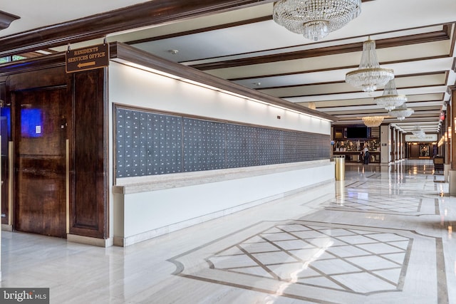 hallway featuring a notable chandelier and wainscoting