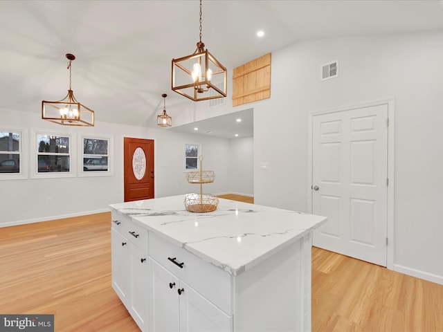 kitchen with visible vents, white cabinets, lofted ceiling, light wood-style floors, and a chandelier