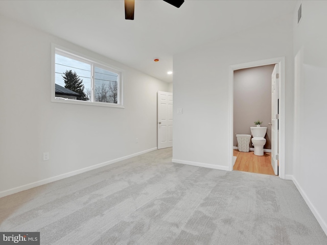 unfurnished bedroom featuring carpet, visible vents, ensuite bath, and baseboards