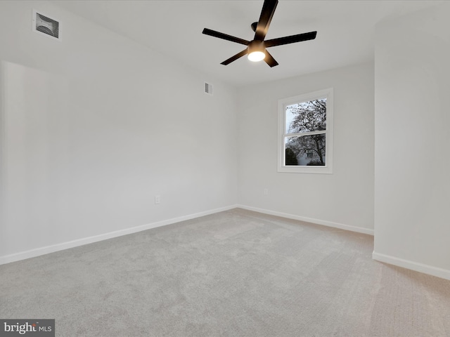 carpeted empty room with visible vents, ceiling fan, and baseboards