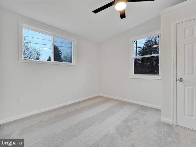 unfurnished bedroom with a ceiling fan, light carpet, and baseboards