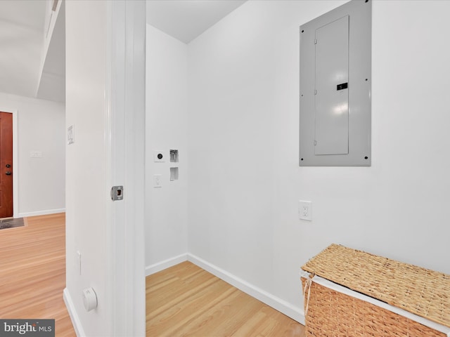 washroom with hookup for a washing machine, hookup for an electric dryer, wood finished floors, electric panel, and baseboards