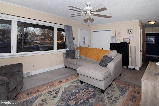 carpeted living area with a ceiling fan, visible vents, a textured ceiling, and baseboards