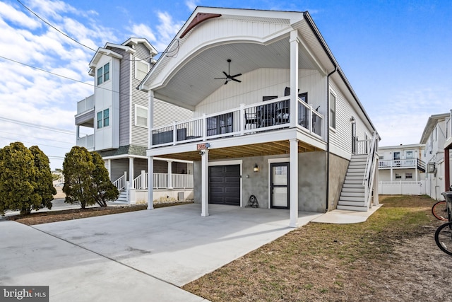 view of front of home with driveway, ceiling fan, a garage, and stairway