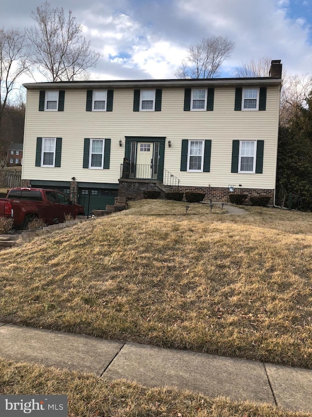 view of front facade featuring a chimney and a front yard