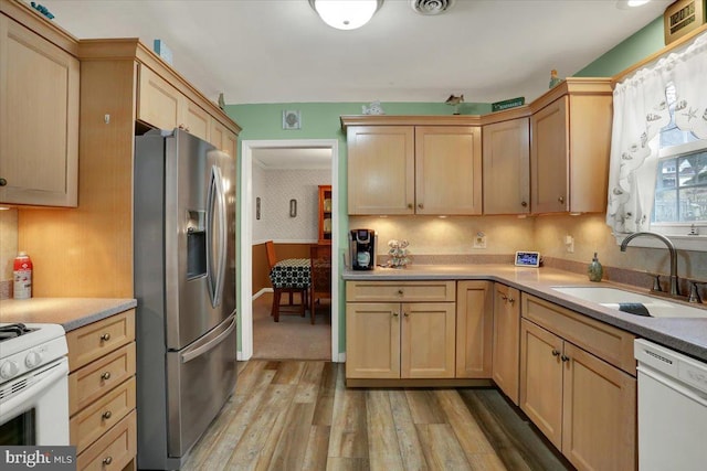 kitchen featuring light wood-style floors, a sink, stainless steel fridge, dishwasher, and wallpapered walls