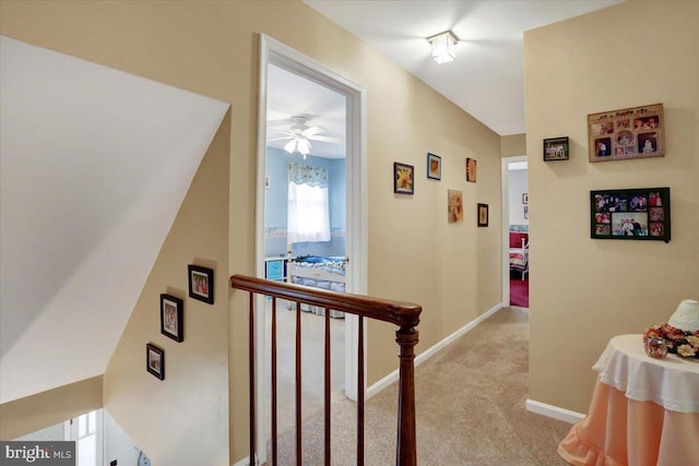 corridor featuring light carpet and baseboards