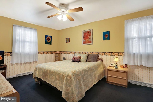 bedroom featuring baseboards, dark carpet, baseboard heating, and wallpapered walls