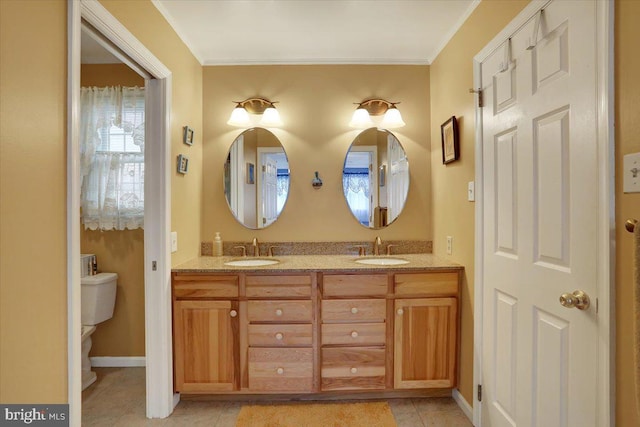 full bathroom featuring double vanity, tile patterned flooring, baseboards, and a sink