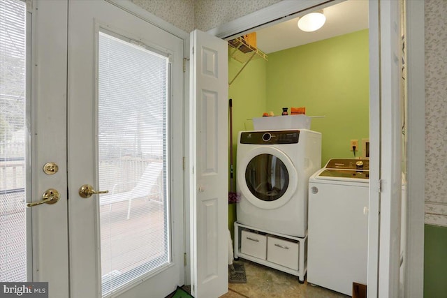 laundry room featuring laundry area, french doors, washing machine and clothes dryer, and wallpapered walls