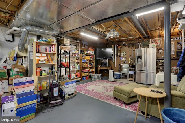 unfinished basement featuring stainless steel fridge