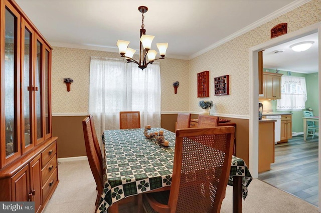 dining area featuring ornamental molding, a chandelier, light carpet, and wallpapered walls