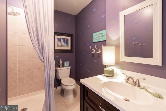 full bathroom featuring toilet, tile patterned floors, a tile shower, and vanity