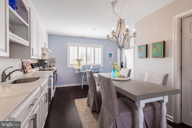 dining room featuring a chandelier, dark wood finished floors, and baseboards