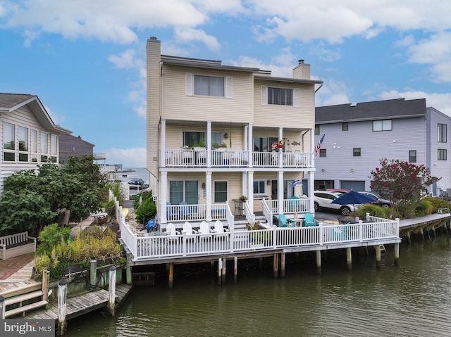 rear view of property featuring a water view and a chimney