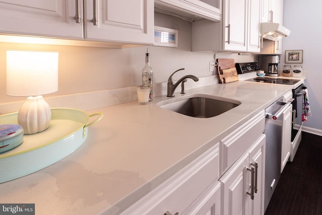 kitchen with under cabinet range hood, white cabinets, a sink, and range with electric stovetop