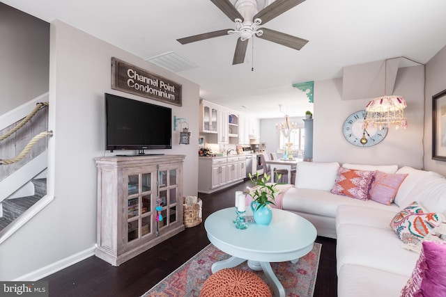 living area featuring visible vents, dark wood finished floors, baseboards, and ceiling fan with notable chandelier