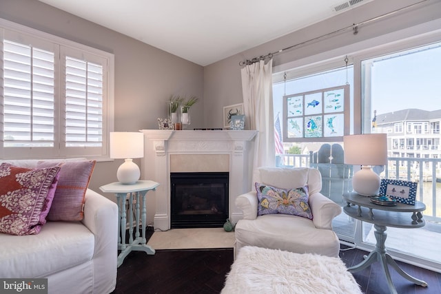 interior space with a premium fireplace, visible vents, and wood finished floors