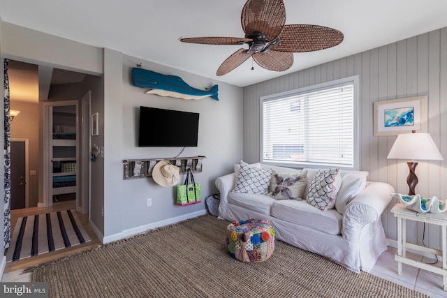 living room with ceiling fan and baseboards