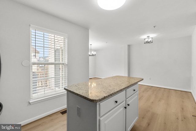 kitchen featuring visible vents, light wood finished floors, a wealth of natural light, and white cabinetry